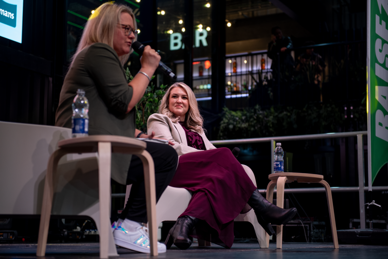 Managing Partner, Sarah Walton, speaking into a microphone as Sara Davies MBE watches